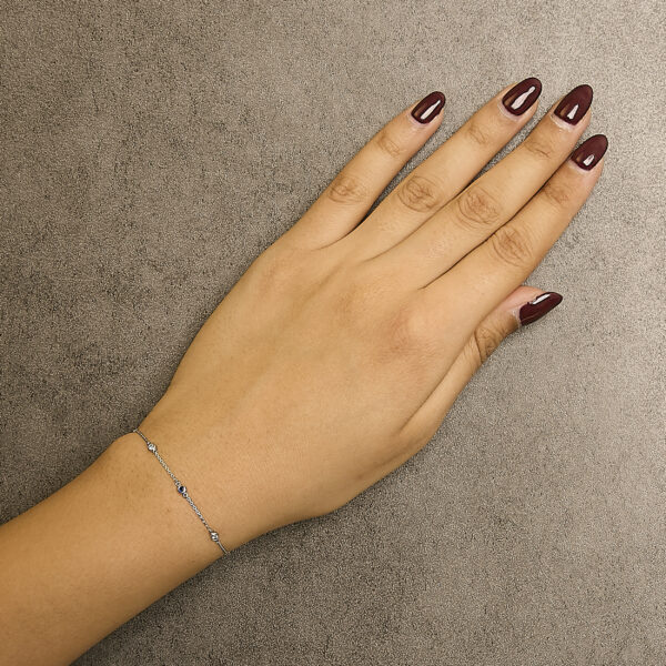 Bracelet worn on a wrist, showing the bezel-set sapphires and diamonds in place