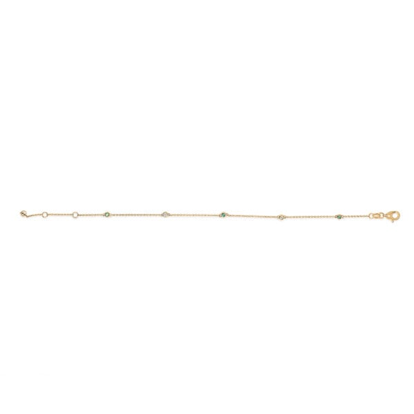 Close-up of bezel-set green emerald and round diamond stations on a yellow gold chain bracelet