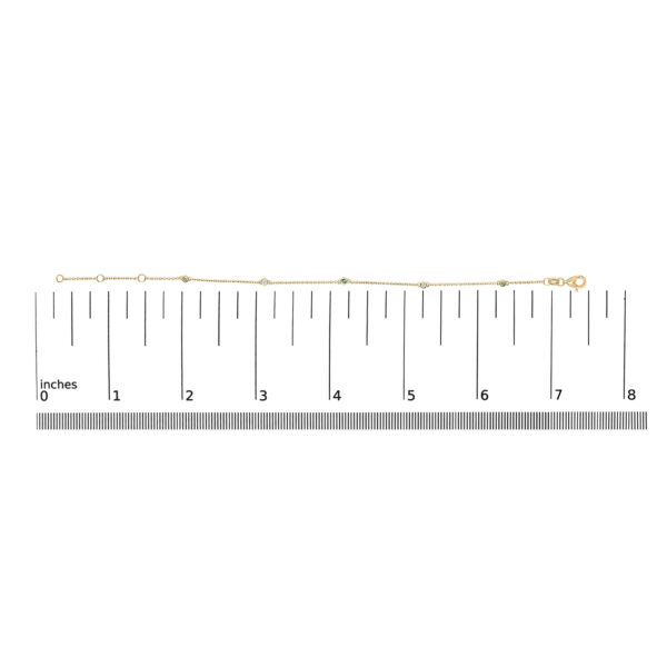 Yellow gold bracelet shown next to a ruler for scale reference