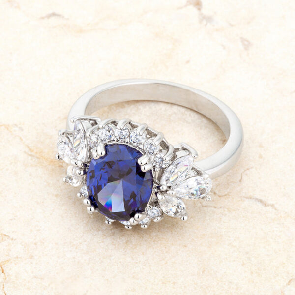 Classic 2.5mm ring with round tanzanite-colored cubic zirconia in prongs and a rhodium plated over lead free alloy (brass) finish.