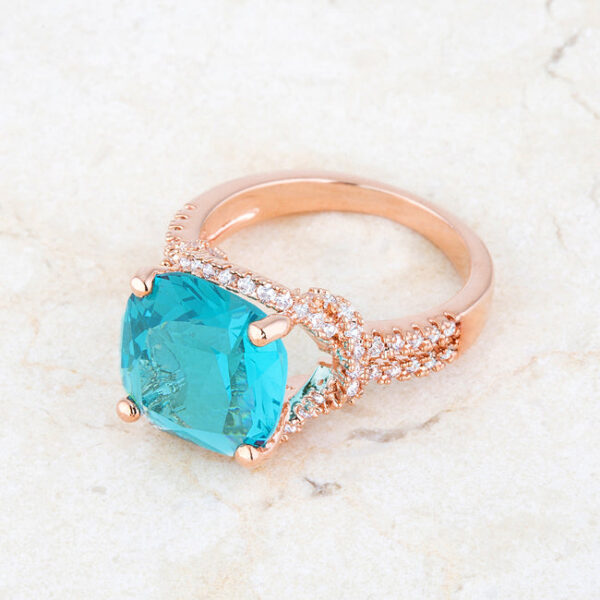 Aqua cubic zirconia classic statement ring in prongs with 6.2 ct total weight and a rose gold tone over lead free alloy (brass) finish.