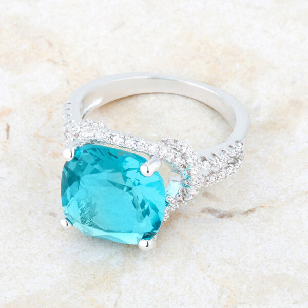 Rhodium plated over lead free alloy (brass) ring with aqua cubic zirconia in cushion and round cuts and prongs.