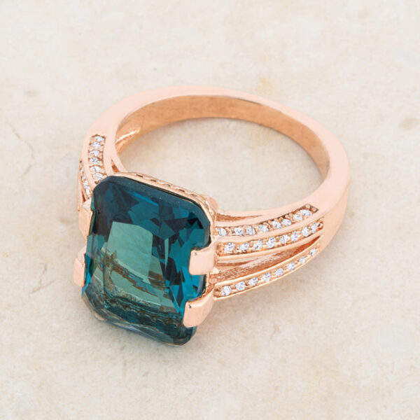 Rose goldtone plated cocktail ring shown at an angle displaying the full band and stone