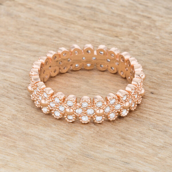 Round cubic zirconia eternity ring in rose gold tone over lead free alloy (brass) with textured bezel detailing.