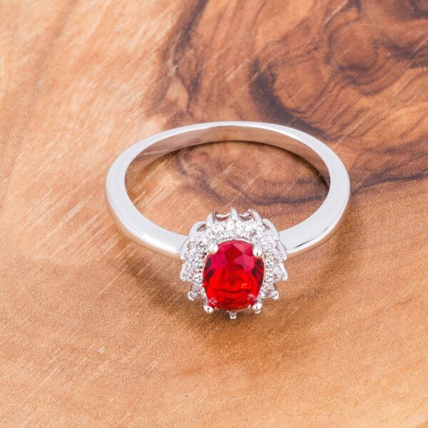 Classic ring with oval-cut ruby-colored cubic zirconia held in a prong setting and a silver tone over brass finish.