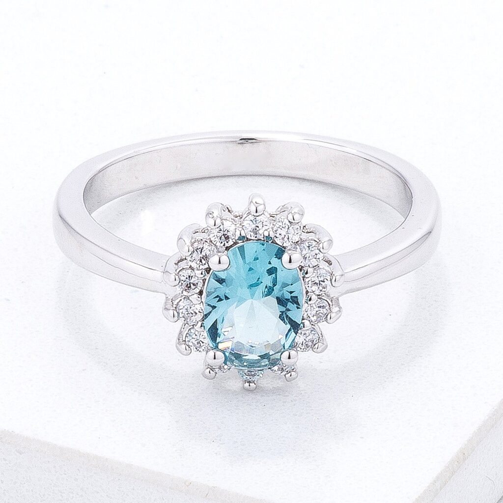 Silver tone over brass ring with blue oval cubic zirconia in a prong setting.