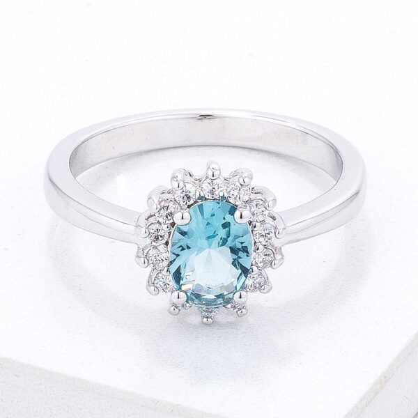Silver tone over brass ring with blue oval cubic zirconia in a prong setting.