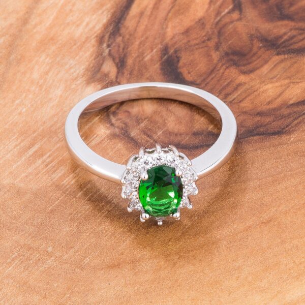 Close-up of the ring's band and prong-set green oval stone from a slight angle