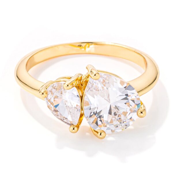 Toi et Moi ring in gold tone over lead free alloy (brass) with pear-cut cubic zirconia.