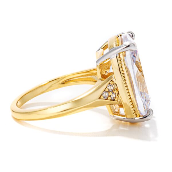 Elongated cushion cut detail on a gold tone engagement ring.