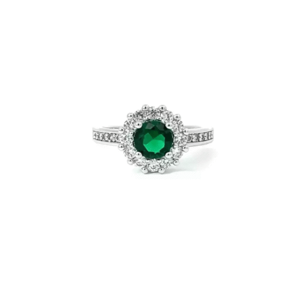 Green round cubic zirconia in prongs on a rhodium plated over lead free alloy (brass) engagement ring.