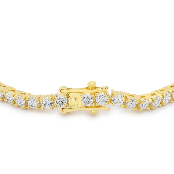 Close-up of round cubic zirconia stones held in prong settings on a goldtone finish plated bracelet