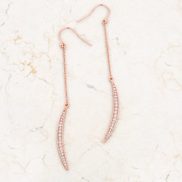 Pair of rose goldtone plated moon drop earrings laid side by side showing matching pave stone setting