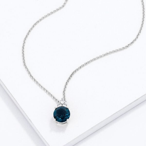 Close angle of the blue green cubic zirconia pendant showing the range of stone sizes