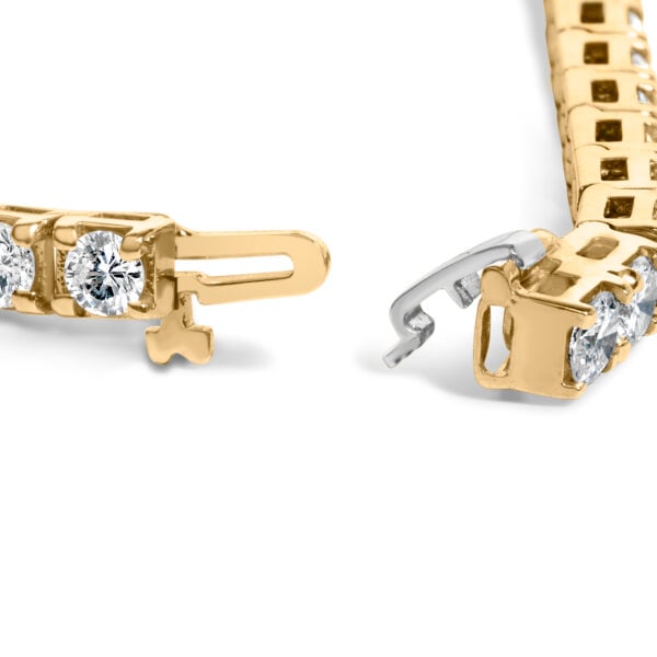 Close-up of round diamonds set in yellow gold prongs along the bracelet