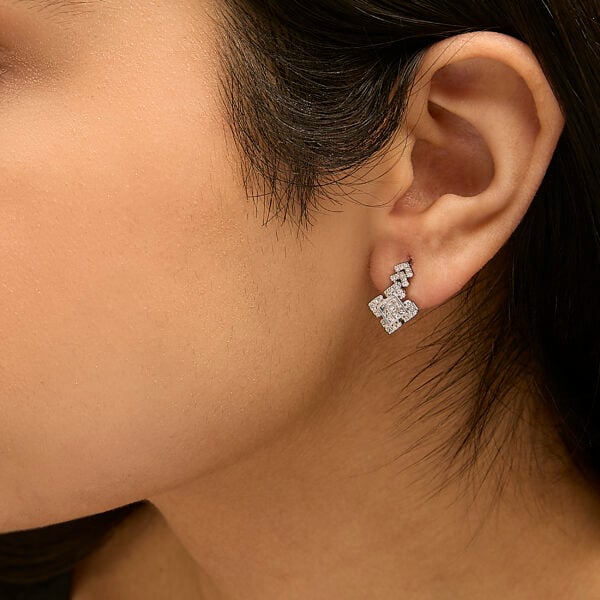Earrings worn on a model's ear showing how the drop hangs in wear