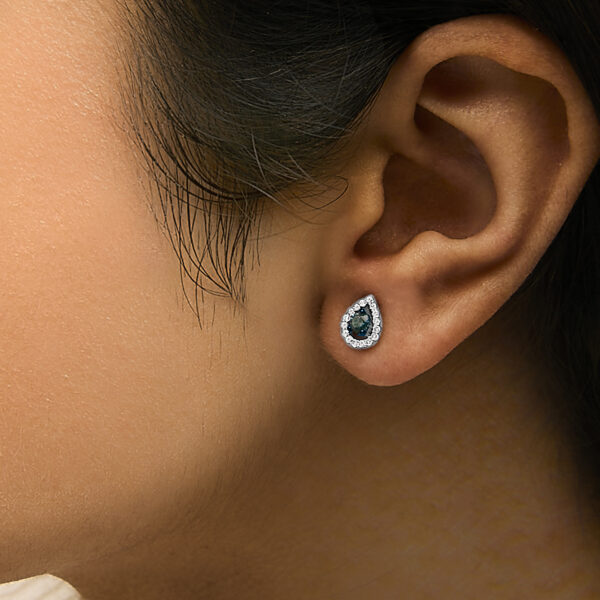 Pear shape halo stud earrings worn on a model's ear