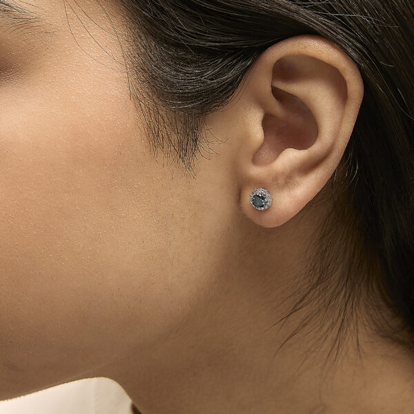 Stud earrings shown worn on an ear to show placement and fit