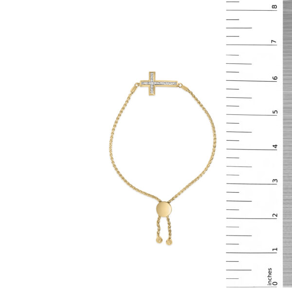 Vermeil cross bolo bracelet pictured next to a scale reference for size comparison