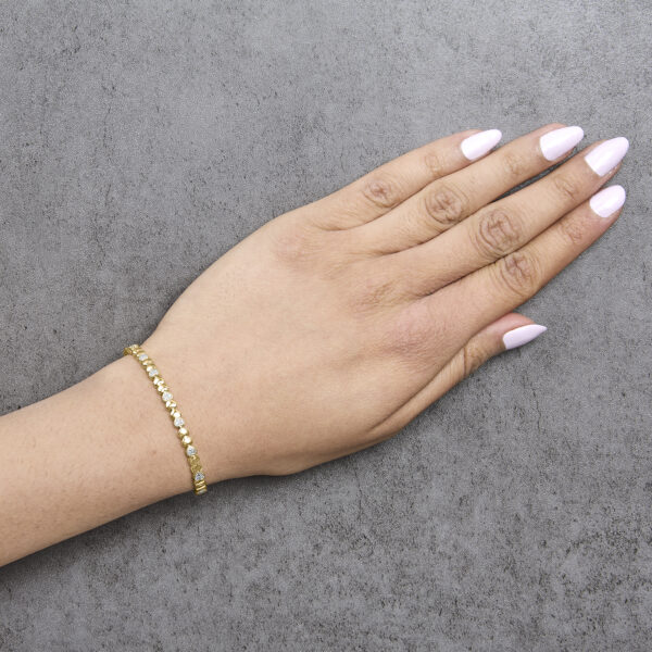 24K gold plated diamond puff heart bangle bracelet worn on a wrist