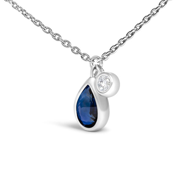 Close-up of the pear blue sapphire and diamond accent in bezel settings on the pendant