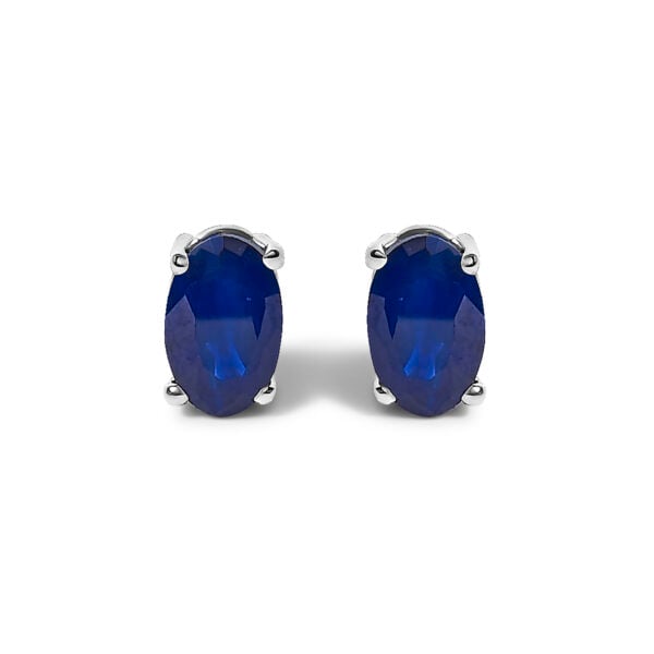 Pair of oval blue sapphire stud earrings in a rhodium plated sterling silver 4-prong setting