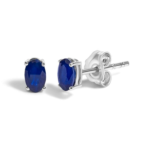 Close-up of a single oval blue sapphire stud earring showing the checkerboard cut facets