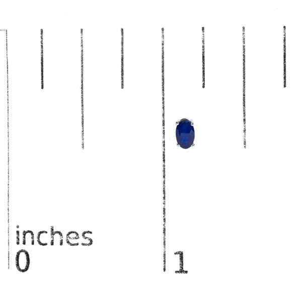 Sapphire stud earrings shown next to a scale reference to indicate their size