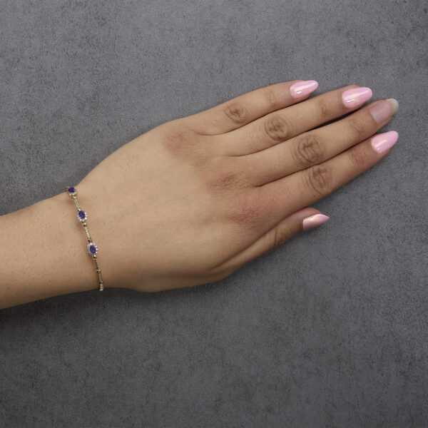 Bracelet worn on a wrist showing the amethyst and diamond stations in place