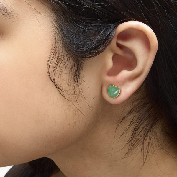 Jade heart stud earrings shown worn in an ear