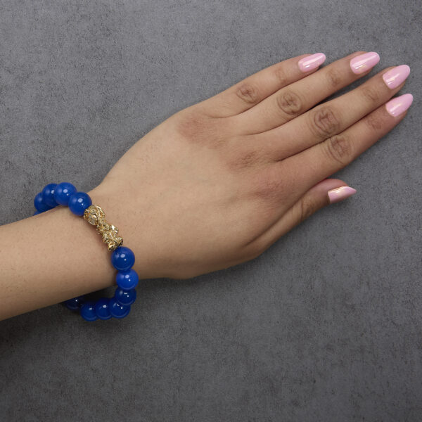 Bracelet worn on a wrist showing the beaded strand and dragon charm in place