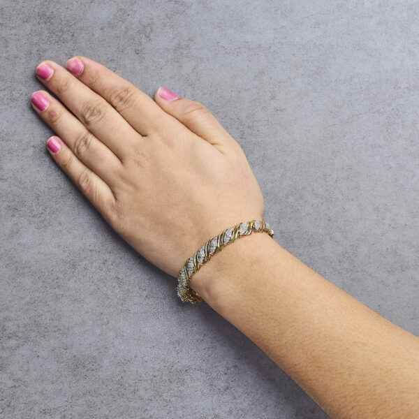 S-link twist bracelet in 10K yellow gold worn on a wrist to show fit