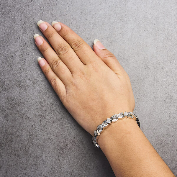 Bracelet worn on a wrist, showing the box clasp and safety latch closure