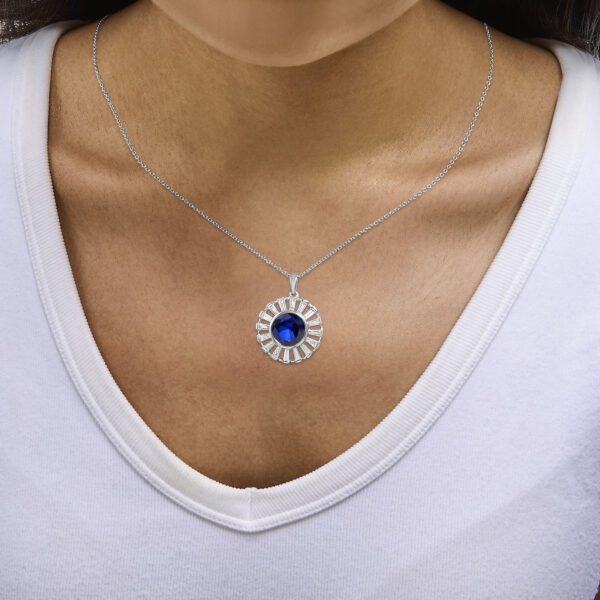 Pendant necklace displayed as worn, showing the cable chain and medallion resting at the neckline