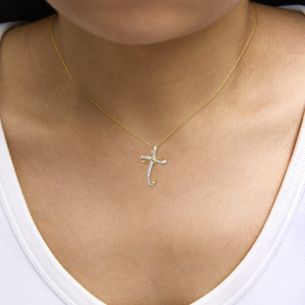 Infinity cross pendant necklace laid out to show scale and dimensions