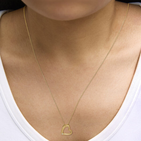 Heart pendant necklace worn at the neckline