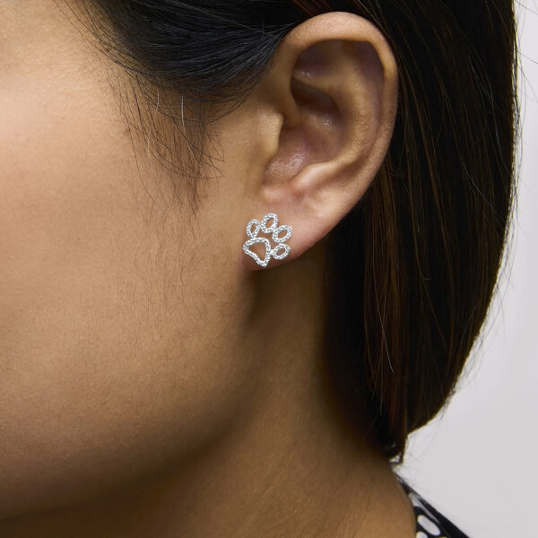Paw stud earring worn in an ear, shown from an angle
