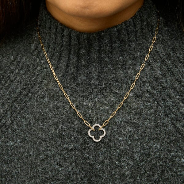 Clover pendant necklace worn at the collarbone on a model